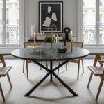 Dining room with a round marble table and wooden chairs.