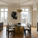 Dining room with a glass table and chairs in a stylishly decorated room.